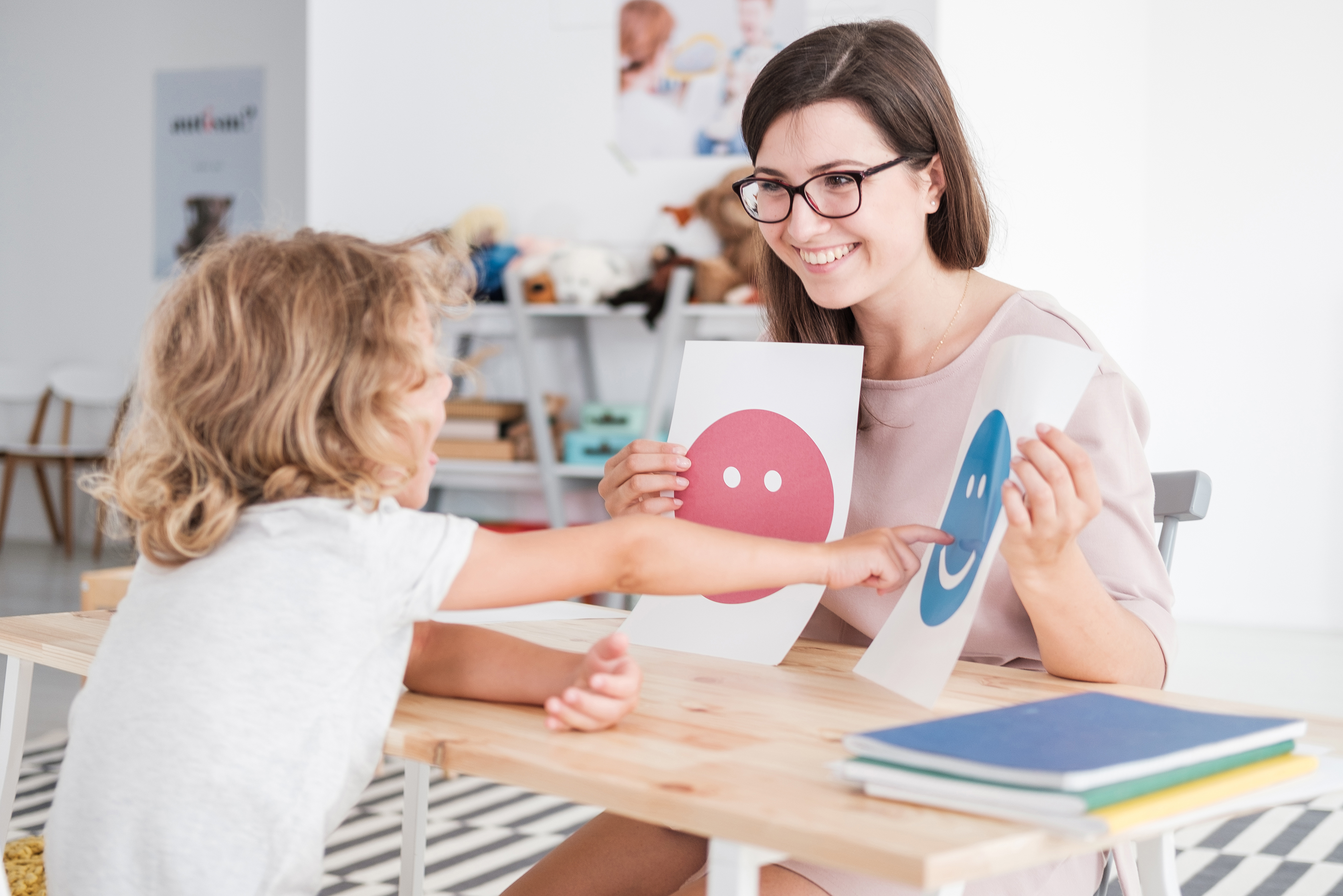 Teacher holding pictures during meeting with young patient