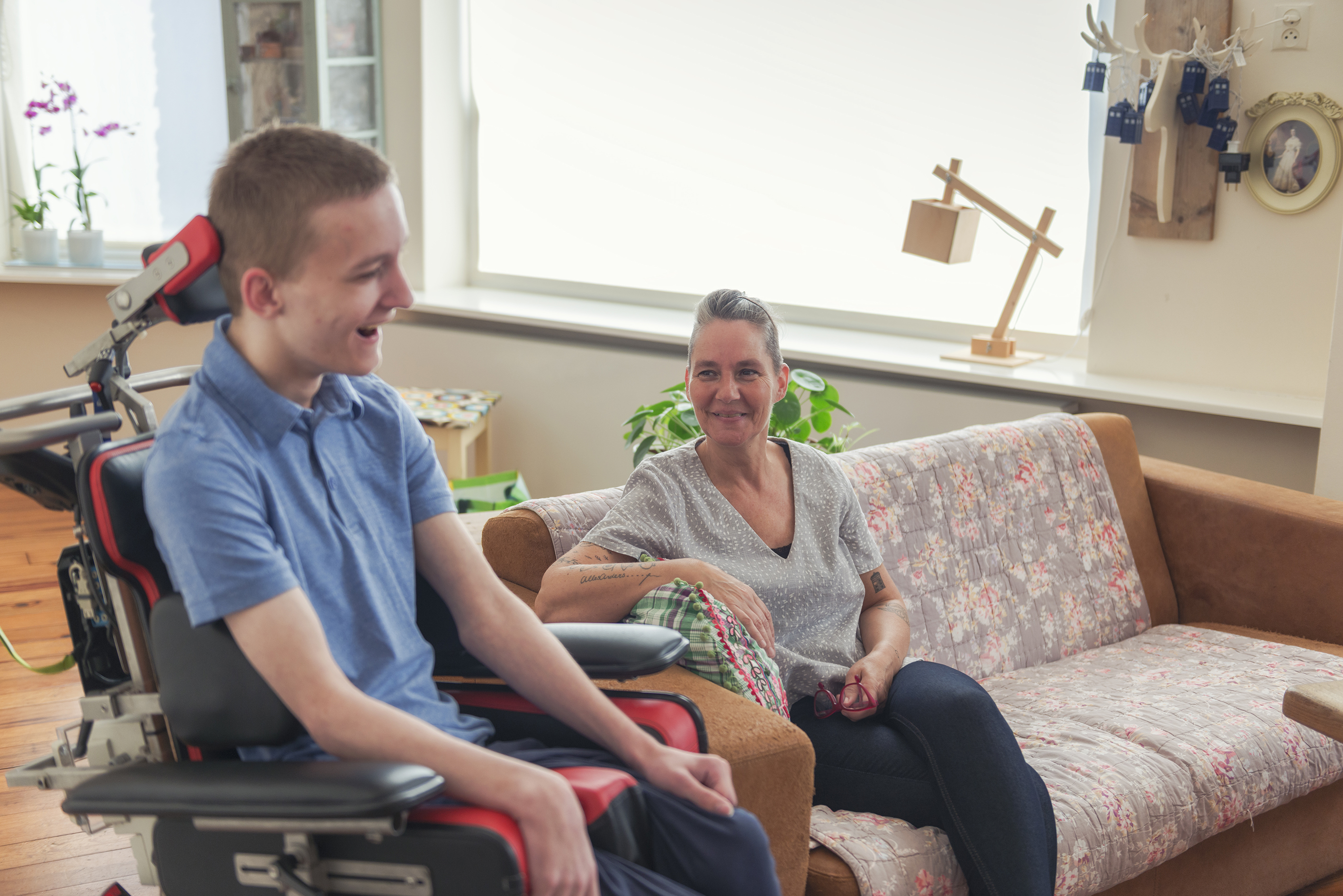 Mobility impaired child sat with his mother in the front room